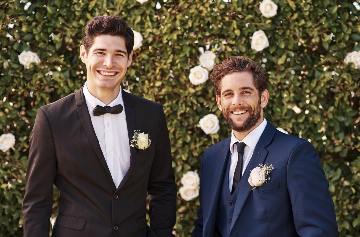 A groom standing with his groomsmen, wearing suits. They chose suits vs. tuxedos, with the groom using a bow tie to distinguish himself from the long tie wearing groomsmen