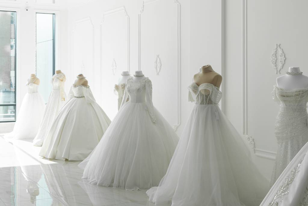 A row of wedding gowns in a bridal boutique.