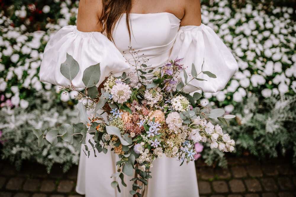 Bride in white dress holding a flower bouquet.