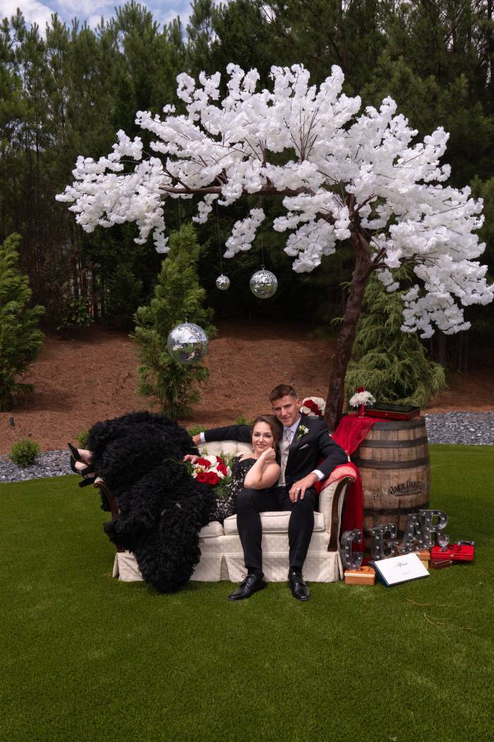 A newlywed couple is enjoying the beautiful venue at Cherokee Valley, wearing her exquisitely made Dimitra Designs modern black wedding dress.