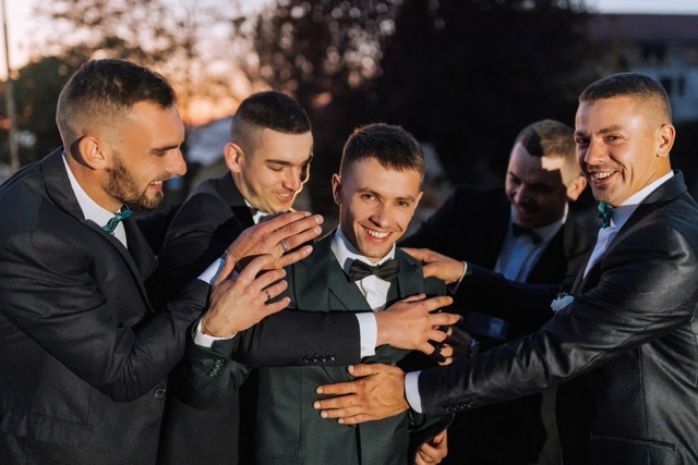 A groom surrounded by his groomsmen.
